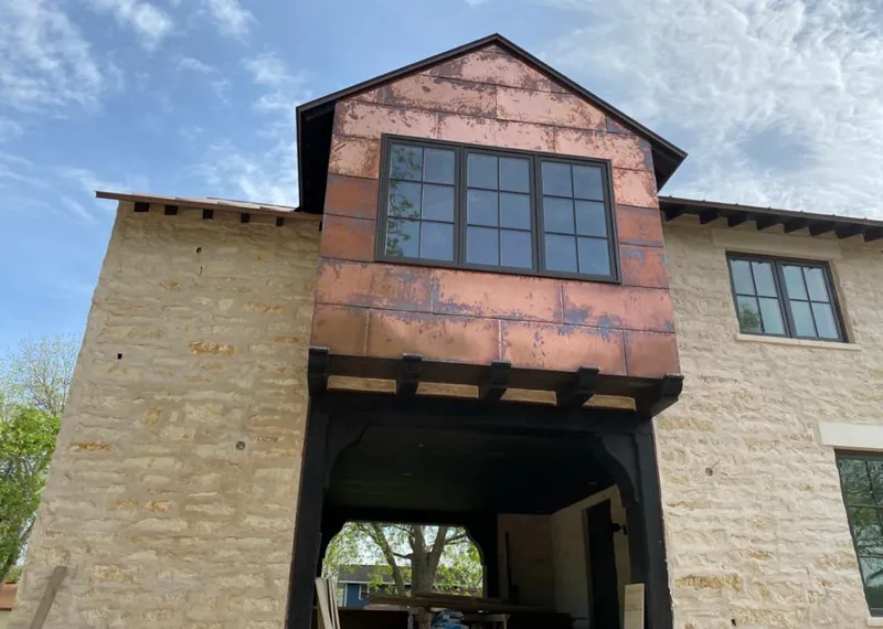 Copper metal panel facade on a stone building for Skylight Installation in Southeast
